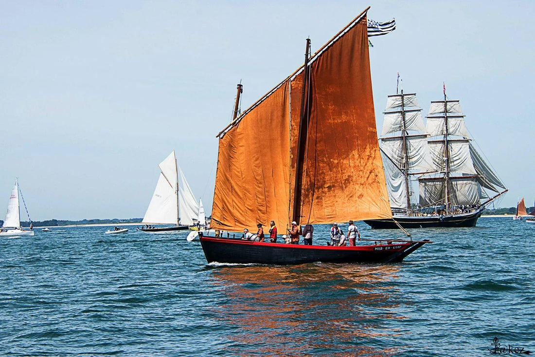 Le Sinagot bateau Mab et Guip avec les voiles rouges sur le Golfe avec un voilier ancien en fond