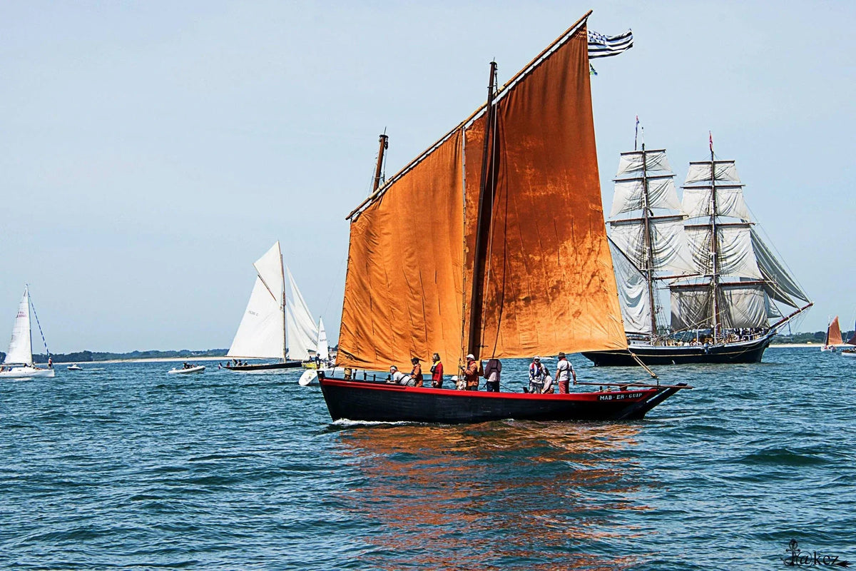 Le Sinagot bateau Mab et Guip avec les voiles rouges sur le Golfe avec un voilier ancien en fond