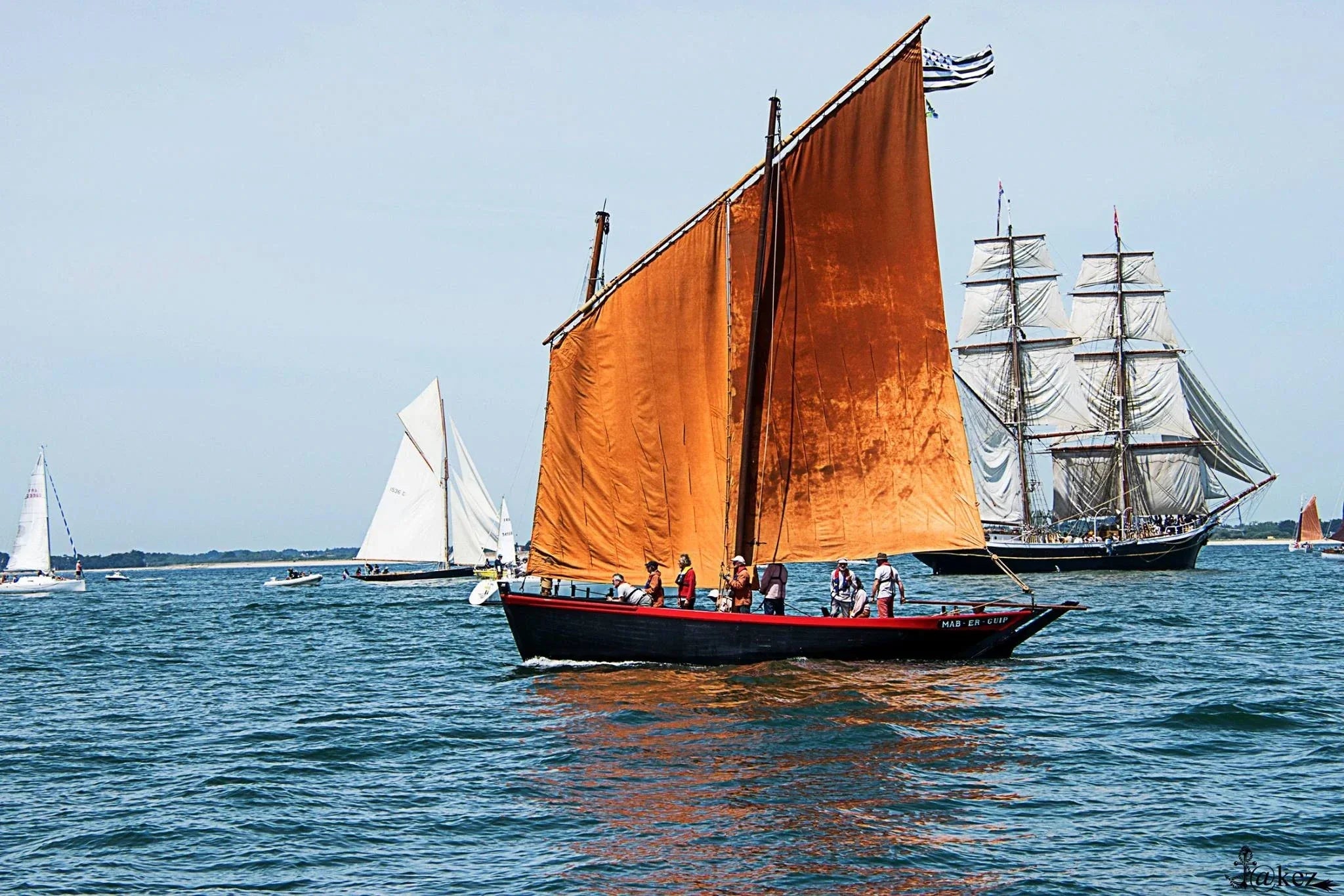 Le Sinagot bateau Mab et Guip avec les voiles rouges sur le Golfe avec un voilier ancien en fond