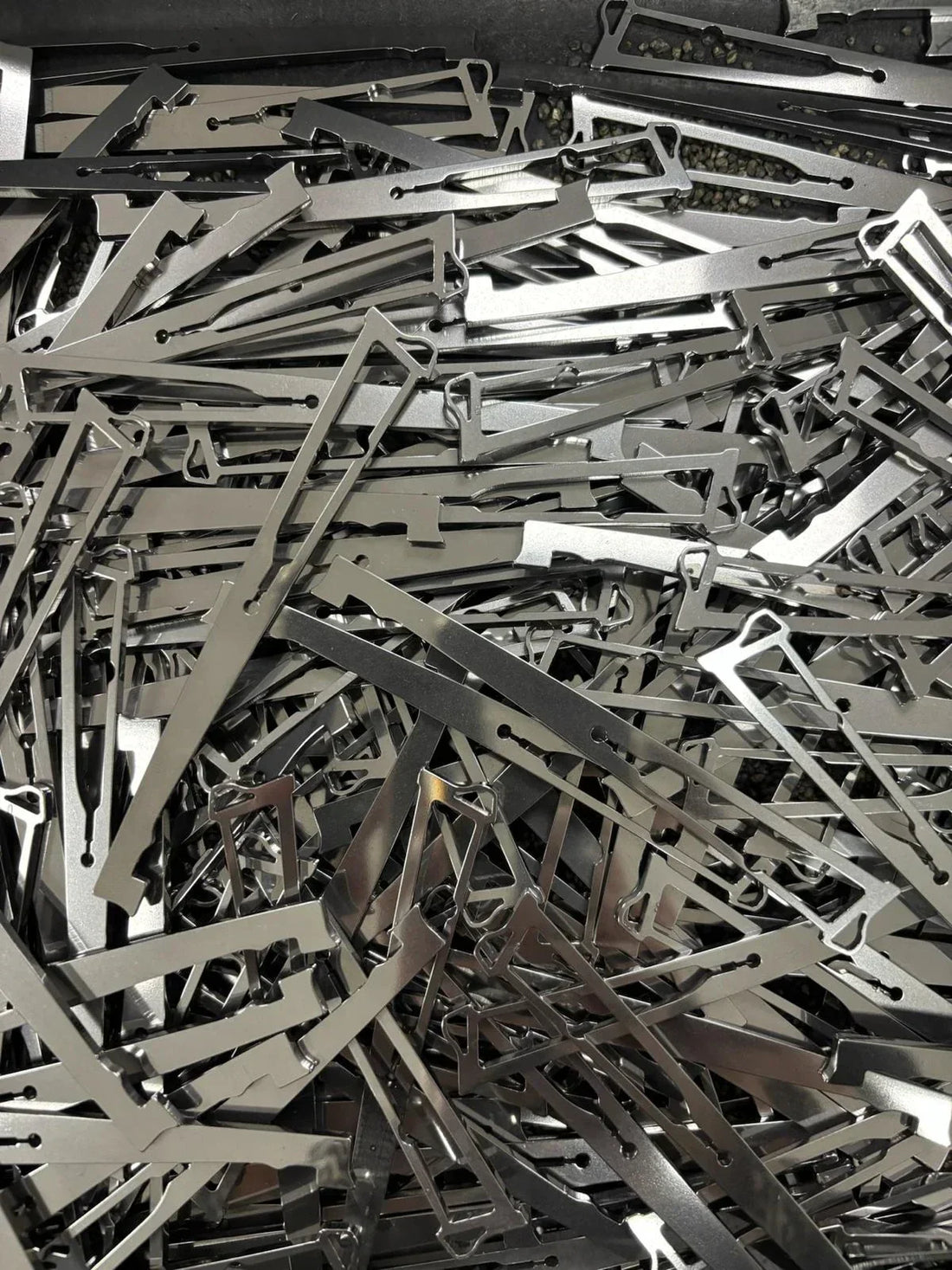 un bac rempli de pièces en acier inox, une pièce du couteau, la pompe