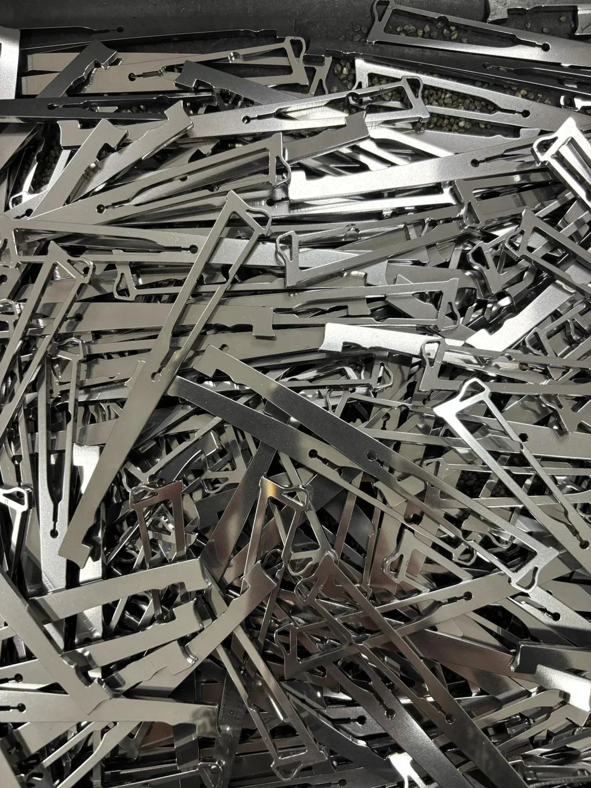 un bac rempli de pièces en acier inox, une pièce du couteau, la pompe